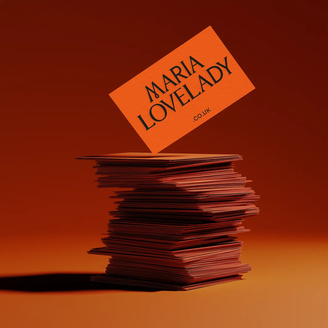 Stack of blood-orange Maria Lovelady business cards with the wordmark on the top card