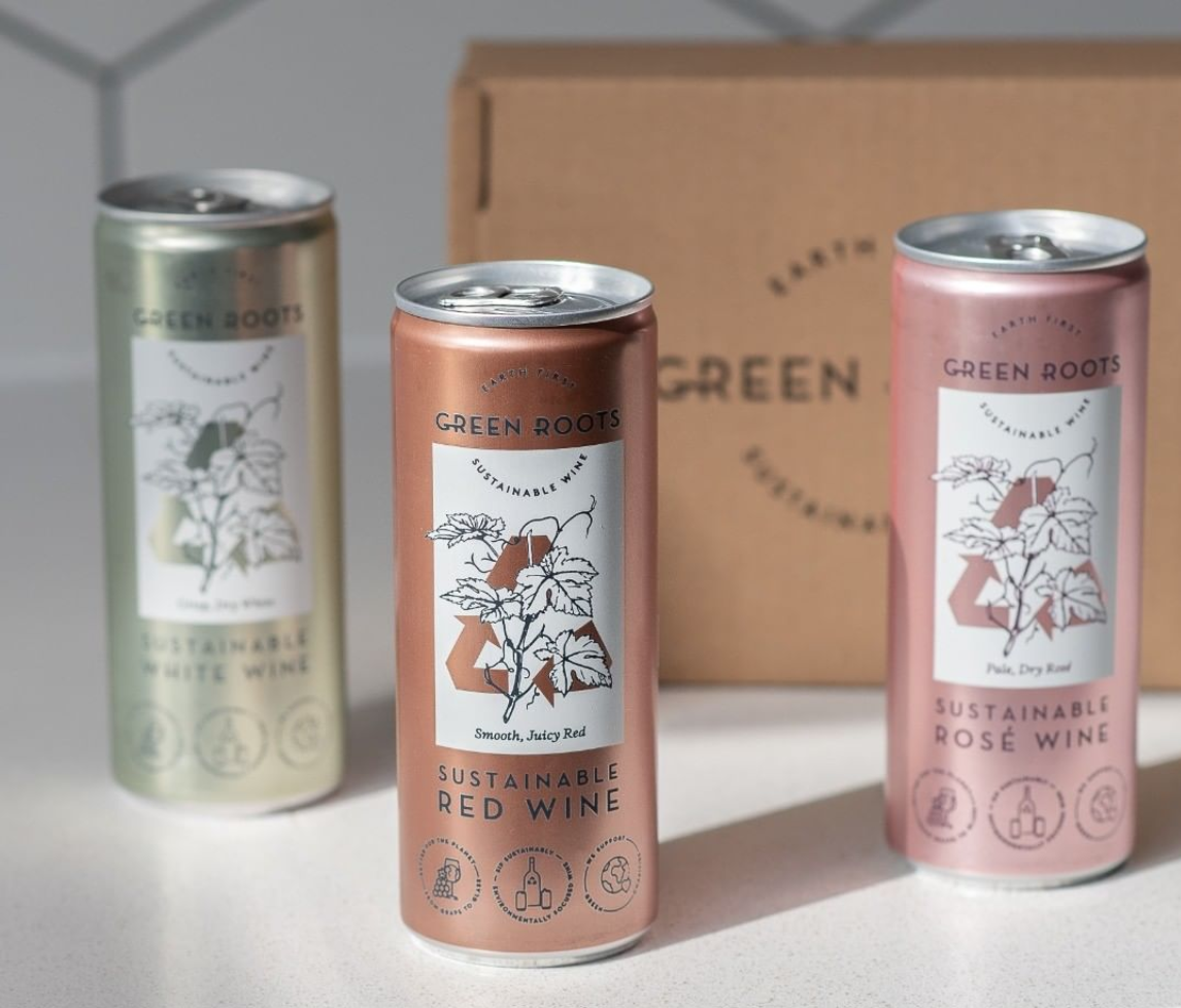 Three Green Roots sustainable wine cans in white, red and rosé in front of a kraft gift box.
